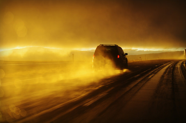 Car driving on wet road at sunset