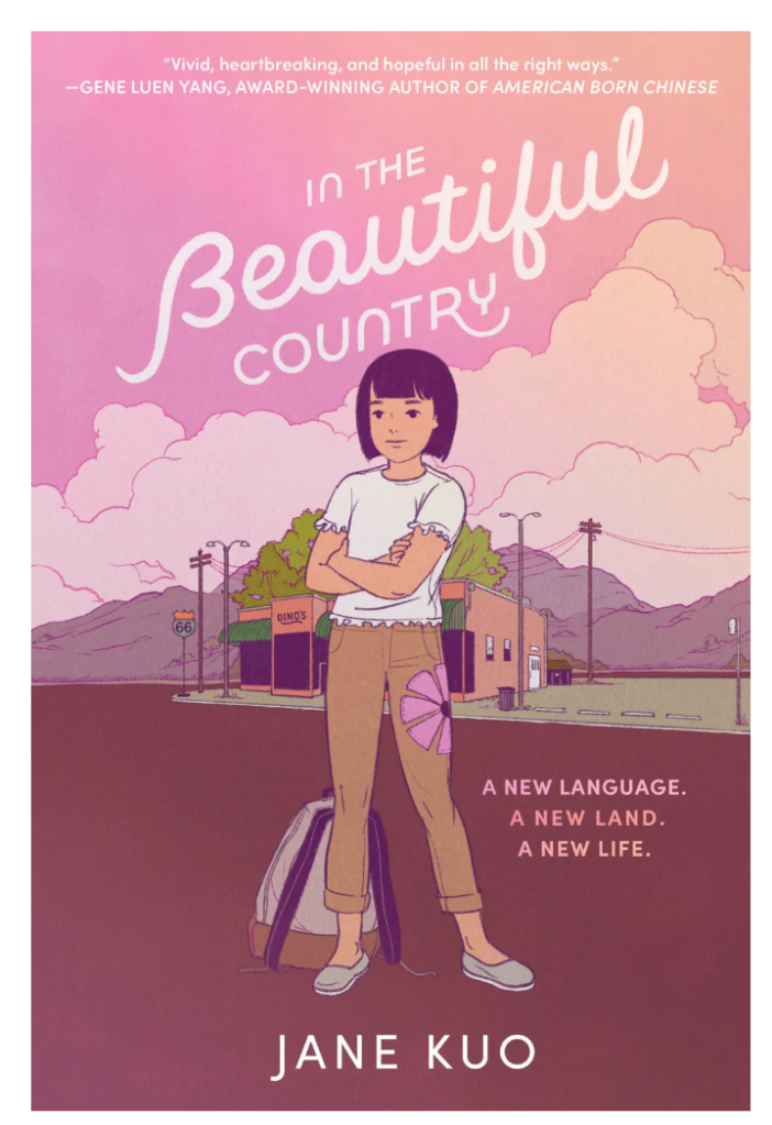 Book cover titled "In The Beautiful Country" by Jane Kuo. The background is in shades of pink and lavender, with stylized clouds and a scene that includes a street and distant mountains. In the foreground, there's a young Asian girl with short black hair, wearing a white T-shirt and beige pants. She stands confidently with her arms crossed, beside a suitcase and holding a butterfly kite. The cover features a quote from Gene Luen Yang stating the book is "Vivid, heartbreaking, and hopeful in all the right ways." The cover also describes the book with the phrases "A new language. A new land. A new life."